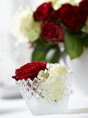 Red and white roses in a crystal glass