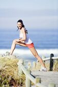 Frau macht Fitnessübung am Strand