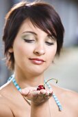 Young woman with a cherry on her hand
