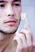 Man massaging face with brush