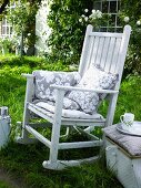 White rocking chair with cushions in garden