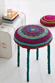 Colourful crocheted cushion on stool