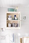 Crockery in small, wall-mounted cabinet in Scandinavian summer house