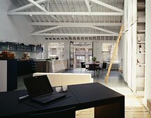 Loft in a former factory building with black writing desk and open kitchen