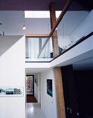 Split level in an apartment with a view of a hallway and a mezzanine with wooden supports