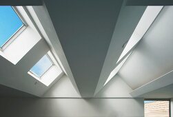 View of ceiling in top floor of contemporary building with skylights in sloping roof