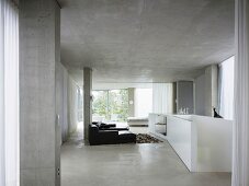 Open living room in concrete with enclosed white banister around a stairway