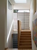 Narrow stairwell with wooden stairs and entry area with front door