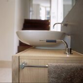 A modern wash basin on a wooden cupboard