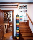 Colourful column lamp between wooden steps to child's bedroom and view of two flights of stairs