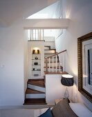 Bedroom with access to ensuite bath via a small, winding wooden stairway and illuminated niche with shelves and ornaments