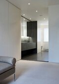 Minimalistic dressing room with wide opening to designer bathroom