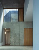 Empty foyer with large transom window and open doorway in concrete block wall