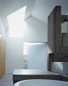 Modernes Bad mit Raumteiler und Ablage aus Beton in zeitgenössischer Architektur mit Oberlicht