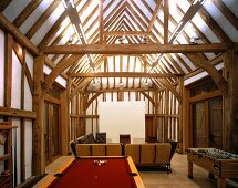 Games tables in open-plan living room of converted barn