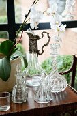 Various crystal carafes on side table