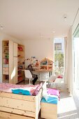 Bett und Regalkombination aus Holz in hellem Kinderzimmer