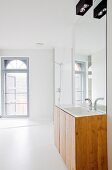 Weisses modernes Bad mit Rundbogenfenster und Waschtisch unter Spiegelwand