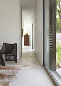 Narrow, open hallway between two rooms in minimalist, ethnic style