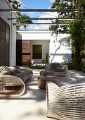 Light and shadow play on modern terrace with large but delicately crafted patio furniture and tables made from old trunks of tropical trees