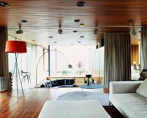Grosszügiger offener Wohnraum mit heller Couch und verschiedenen Stehlampen aus Bauhauszeit