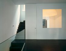 View of living room through large glass panel in stairwell