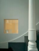 Pane of glass recessed in wall next to staircase