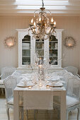 White, Neo-Rococo chairs around set dining table in country-style dining room