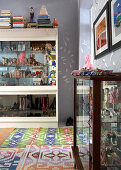 Collection of toys in display case and colourful rugs on floor