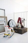 Miniature rocking horse, picture frames, wall clock, wooden crate and large letter on white surface
