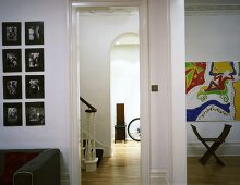 Zeitgenössisch gestylter Wohnraum mit offener Tür und Blick ins Treppenhaus