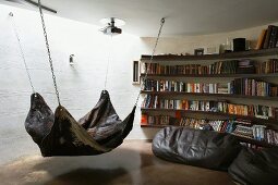 Indirect light from above in round reading corner with animal skin hammock and beanbags