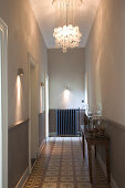 Hallway in period apartment lit by modern sconce lamps and ceiling lamp made from glass spheres