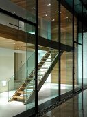 Glass wall of contemporary house with view of illuminated stairwell
