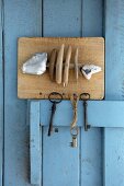Hand-crafted key holder with fish motif made from driftwood and limestone pebbles