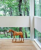 Horse sculpture on floor in front of windows