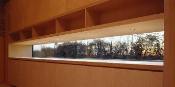 Einbauschrank aus Holz mit integriertem schmalem Fenster