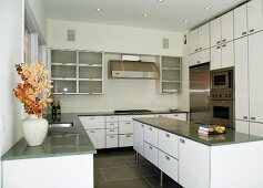 Designer kitchen with central island and white cupboard doors