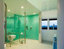 Spacious bathroom with turquoise tiled walls in toilet and shower area