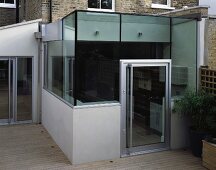 Contemporary glass extension on wooden terrace