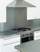 Kitchen unit with gas hob beneath extractor hood