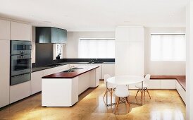 White, stylish, open-plan kitchen with Bauhaus chairs in dining area