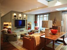 Upholstered seating in front of made-to-measure living room cupboards with flat-screen TV
