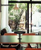 Black platter with pedestal on dining table in open living-dining room with sliding doors leading to garden