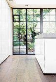 Historic glass wall with metal frame and solid wooden floor in modern kitchen