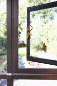 Historic metal window with brass latch on open casement