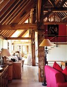 Various seating areas in barn converted into apartment with exposed roof timbers