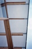 Detail of roof overhang - roof of plastic panels on wood beam frame