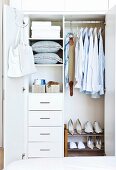 Well organized clothes closet with drawers and a shoe rack
