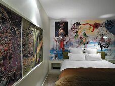Bedruckte Schiebeelemente im Holzrahmen und Wandgemälde hinter Doppelbett im Retro-Hotelzimmer